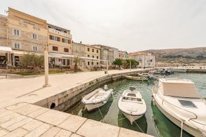 a group of boats docked in a canal with buildings at Laguna Rooms in Pag