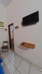 a room with a flat screen tv on the wall at Pousada Berimbau in Arraial d'Ajuda
