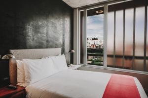 a bedroom with a white bed and a window at Nolitan Hotel SoHo - New York in New York