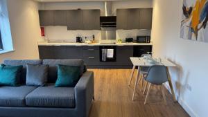 a living room with a couch and a kitchen at Central Old Town 1-Bed Apartment in Swindon