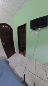 a room with a door and a tv on the wall at Pousada Berimbau in Arraial d'Ajuda +50 photos
