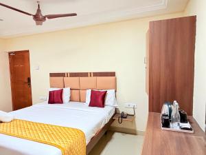 a hotel room with a bed with red pillows at Open Hotel by Olive - G SILVER SS hotel in Tiruppūr