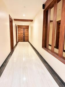 an empty corridor with wooden doors and a hallway with white walls at Open Hotel by Olive - G SILVER SS hotel in Tiruppūr