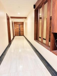 an empty hallway with wooden doors and a floor at Open Hotel by Olive - G SILVER SS hotel in Tiruppūr +23 photos