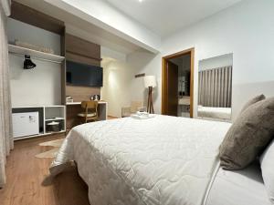 a bedroom with a large white bed and a desk at Zallon Hotel Executivo - Late Checkout Cortesia as 15hs aos DOMINGOS in Lajeado +22 photos