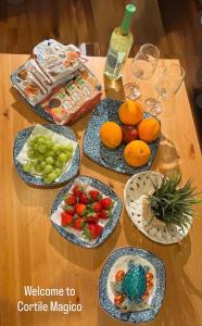 a wooden table with plates of fruit on it at Il Cortile Magico in Syracuse