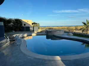 a swimming pool with a chair sitting next to it at Sunny Poolside Escape Near the Beach in Los Barriles