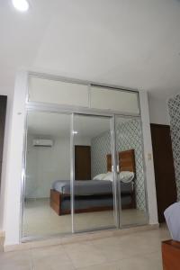 a glass room with a bed and a mirror at Casa con alberca en el centro de Puerto Progreso in Progreso +34 photos