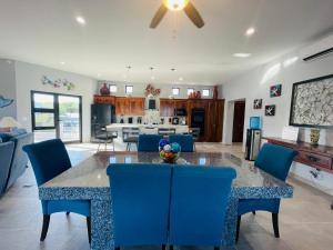 a kitchen and living room with a table and blue chairs at Sunny Poolside Escape Near the Beach in Los Barriles