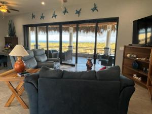 a living room with a couch and a table with stars on the wall at Sunny Poolside Escape Near the Beach in Los Barriles