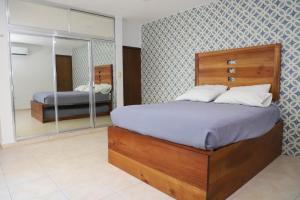 a bedroom with a large bed and a mirror at Casa con alberca en el centro de Puerto Progreso in Progreso