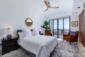 a white bedroom with a bed and a chair at Modern 4BR Villa with Rooftop & Pickleball in Los Barriles +67 photos