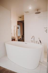 a white bath tub in a bathroom with a mirror at Nolitan Hotel SoHo - New York in New York +39 photos