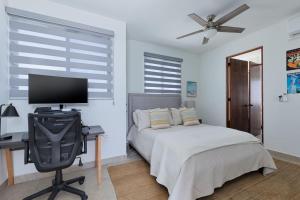 a bedroom with a bed and a desk with a television at Modern 4BR Villa with Rooftop & Pickleball in Los Barriles
