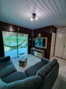 a living room with a couch and a flat screen tv at Cabana do Parque in Presidente Figueiredo