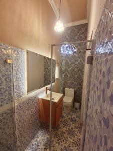 a bathroom with a toilet and a sink and a mirror at Hotel Casa Dharma in Popayan