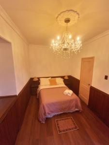 a bedroom with a bed and a chandelier at Hotel Casa Dharma in Popayan
