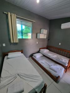 two twin beds in a room with a window at Cabana do Parque in Presidente Figueiredo +52 photos