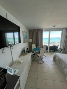 a hotel room with a bed and a table with a television at Ocean View Apartment In Sunny Isles in Sunny Isles Beach