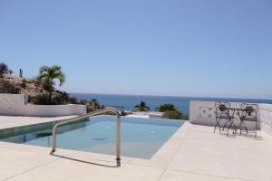 a swimming pool with two chairs next to a swimming pool at Ocean Views Pool 2 Bedroom in Los Barriles