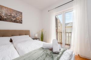 a white bedroom with a bed and a large window at Laguna Rooms in Pag +18 photos