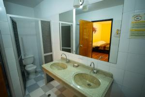 a bathroom with two sinks and a toilet and a mirror at Hotel Guaitipan Ancestral in San Agustín