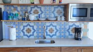 a kitchen counter with a sink and a microwave at Casita GEcko in Buenavista