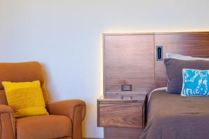 a bedroom with a bed and a chair next to it at Seize the Day at Carpe Diem Condo in Los Barriles