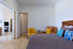 a bedroom with a large bed and two chairs at Seize the Day at Carpe Diem Condo in Los Barriles