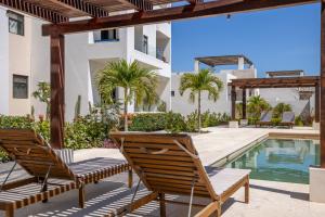 a patio with two chairs and a swimming pool at Seize the Day at Carpe Diem Condo in Los Barriles