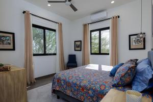 a bedroom with a bed and two windows at Pool with a View in Buena Vista in Buenavista