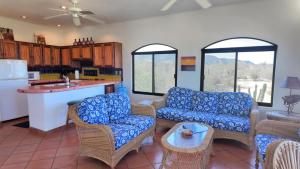 a living room with blue couches and a kitchen at Ocean view casita in Palo Blanco in Los Barriles