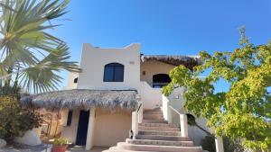 a white house with stairs and a palm tree at Ocean view casita in Palo Blanco in Los Barriles