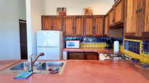 a kitchen with a sink and a white refrigerator at Ocean view casita in Palo Blanco in Los Barriles +9 photos