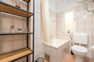 a bathroom with a toilet and a tub and a sink at Laguna Rooms in Pag