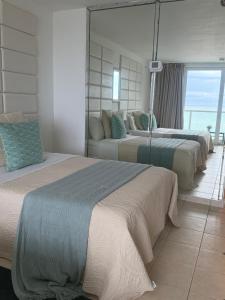 a bedroom with three beds and a view of the ocean at Ocean View Apartment In Sunny Isles in Sunny Isles Beach +7 photos