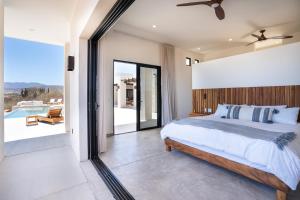 a bedroom with a bed and a balcony with a pool at Stunning Home with Incredible Views in Los Barriles +26 photos