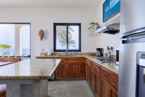 a kitchen with wooden cabinets and a counter top at Beachfront Pool, Rooftop Views & Baja Sunrise in Pescadero