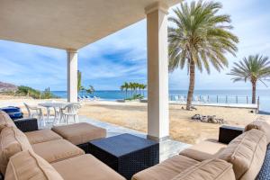 a patio with a view of the beach and palm trees at Beachfront Pool, Rooftop Views & Baja Sunrise in Pescadero
