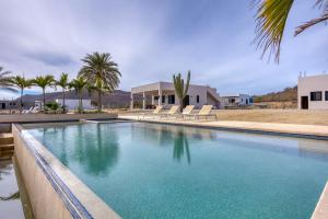 a swimming pool with blue water in front of a house at Beachfront Pool, Rooftop Views & Baja Sunrise in Pescadero