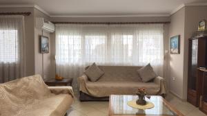 a living room with a couch and a table at Complex Summer Memories Souzan in Keramoti