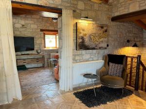 a living room with a chair and a television at Villa Ionis in Volímai