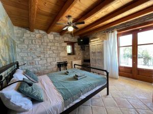a bedroom with a bed and a ceiling fan at Villa Ionis in Volímai +5 photos