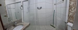 a bathroom with a sink and a glass shower at Solar da Praia in Vitória