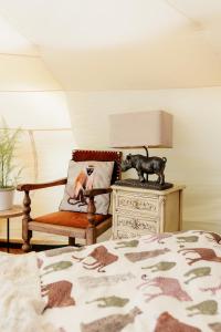 a bedroom with a bed and a lamp and a chair at Wild Retreat in Cawston