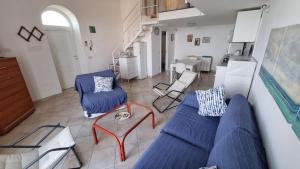 a living room with a blue couch and chairs at Lilli's House in Capri in Capri