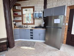 a kitchen with blue cabinets and a stainless steel refrigerator at The Cross Patio Retreat in Buda