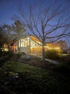 a house lit up at night with lights at The Cross Patio Retreat in Buda +9 photos