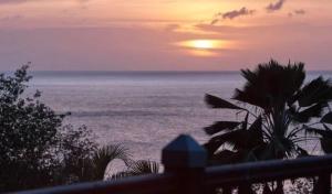 a view of the ocean with the sun in the horizon at Villa Vigie in Deshaies +1 photo