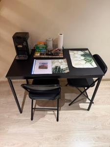 a black table with two chairs and a printer at Le 8 du Pontois in Ciney